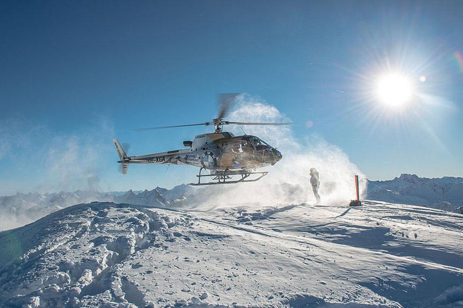 Heliskiing Österreich in Lech am Arlberg. Helikopter hebt ab im Schnee